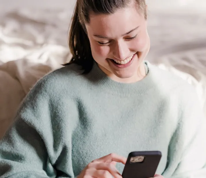 Young woman booking an iron infusion appointment on her phone